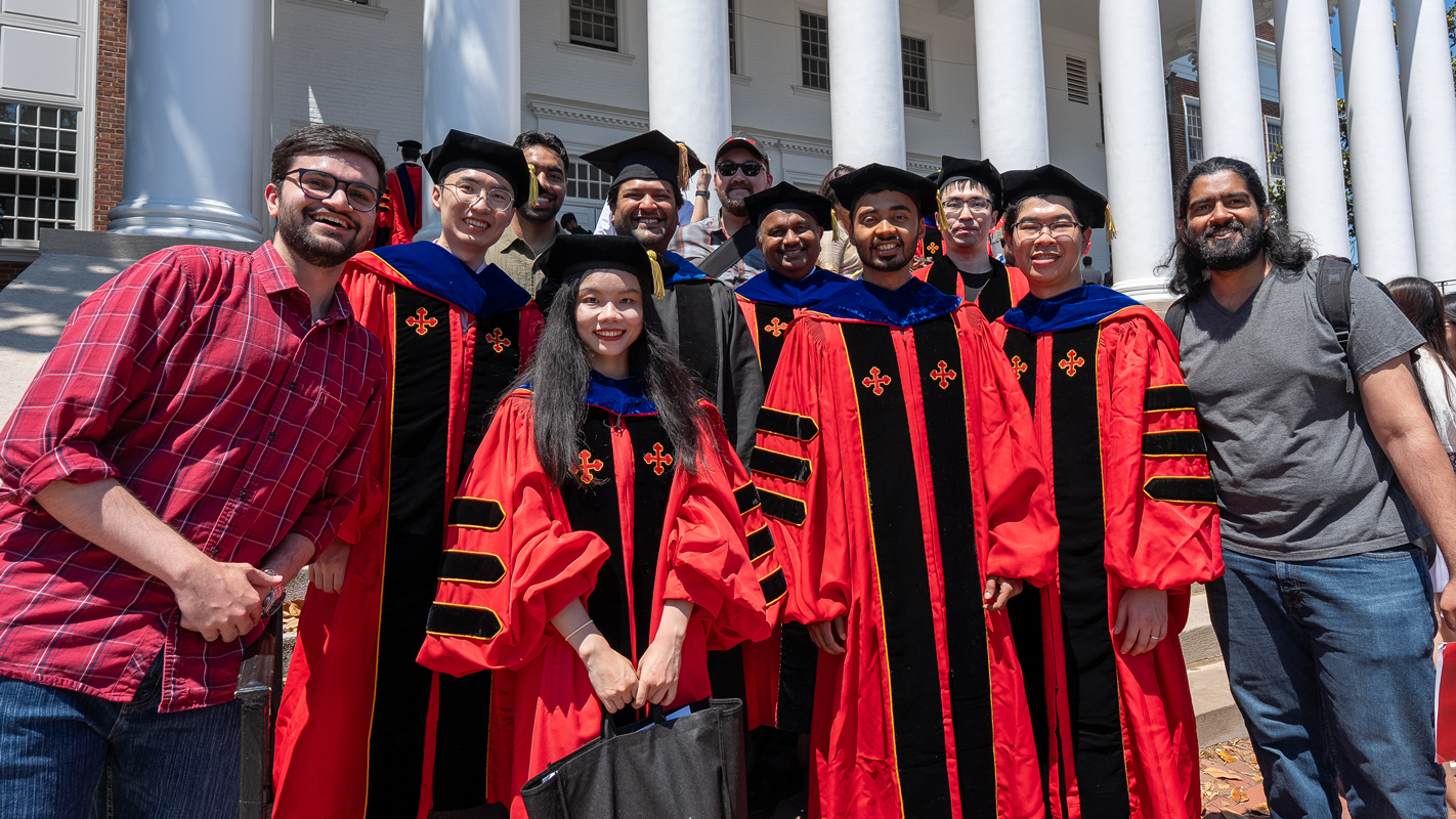 A large group of Ph.D. graduates and their friends celebrating in front of the armory.