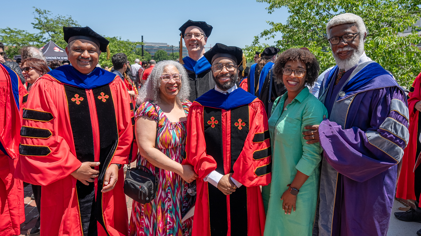 A family with a Ph.D. graduate and the dean outside of the Armory.