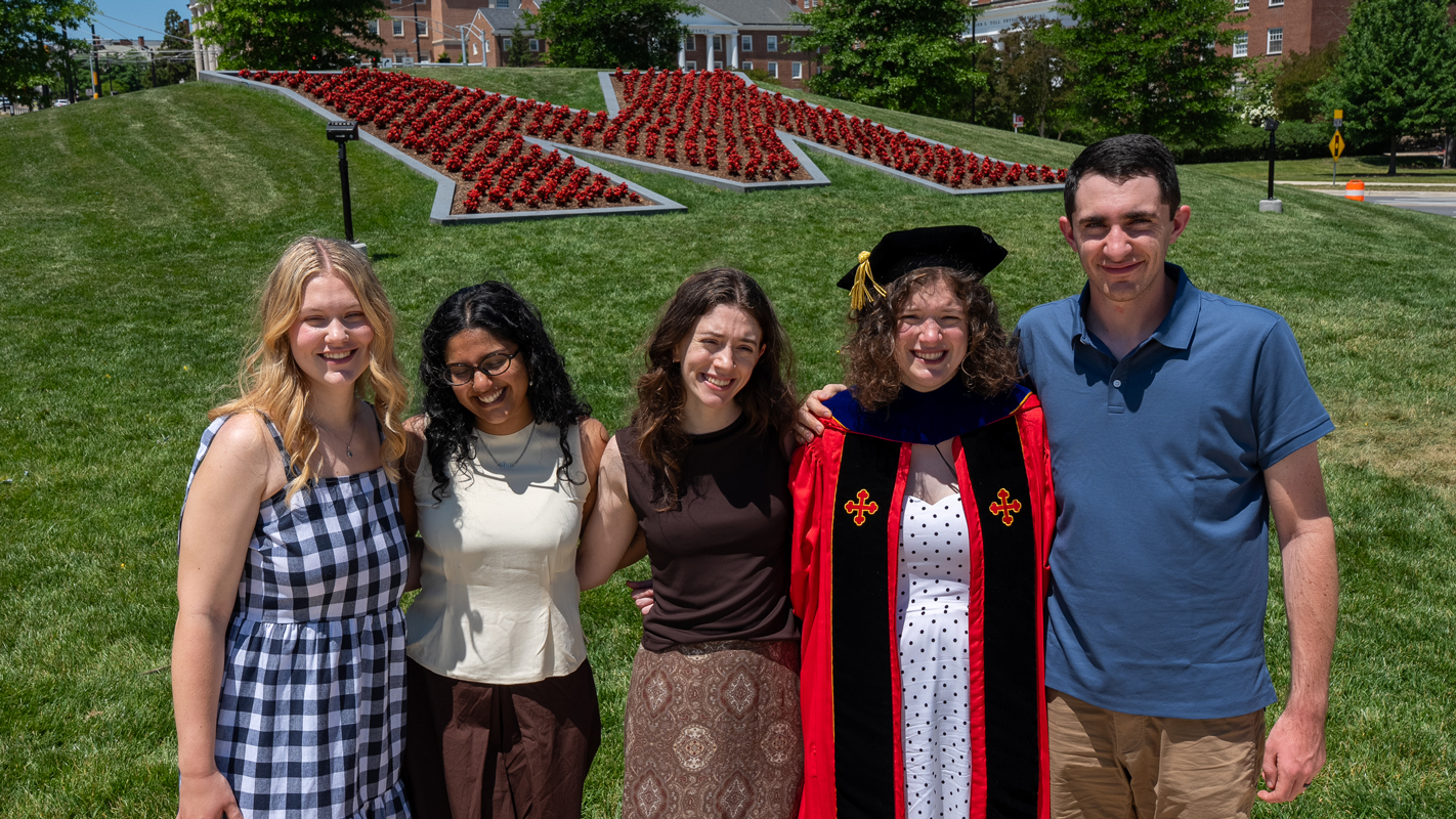 A Ph.D. graduate and her griends posing at the "M Circle."