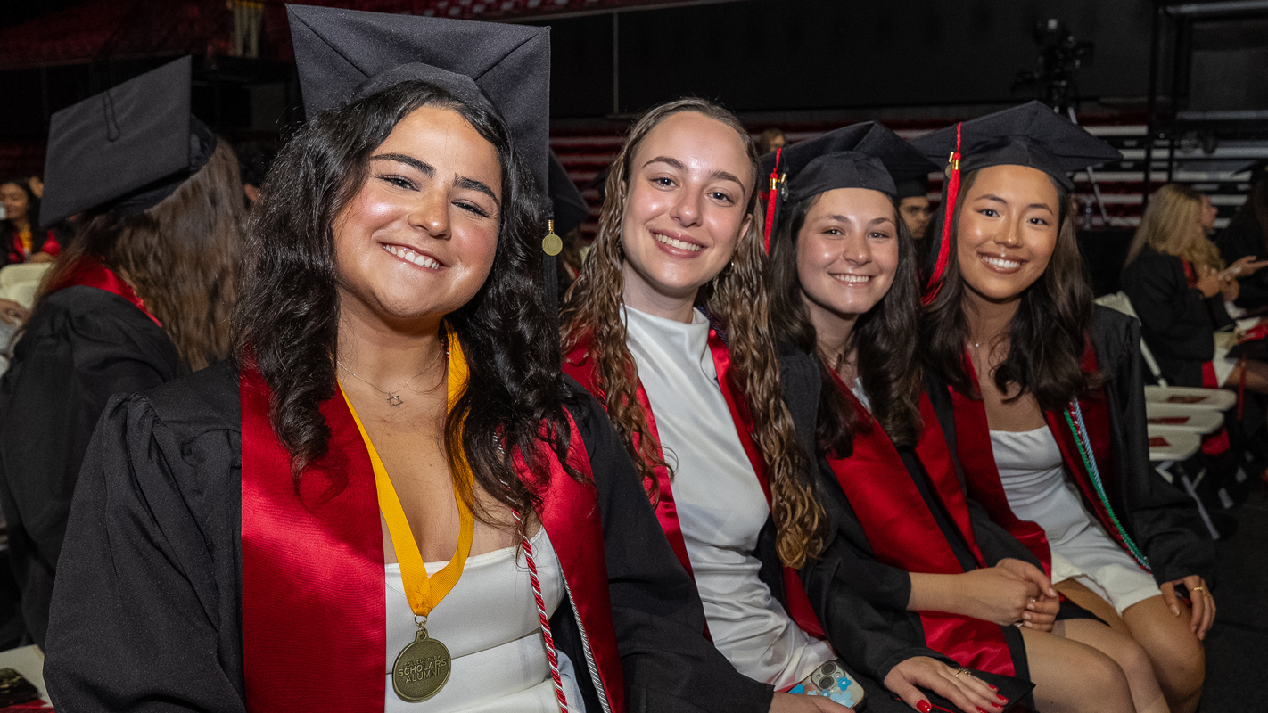 A group of young women in gratuation regalia at the Xfinity Center before the ceremony