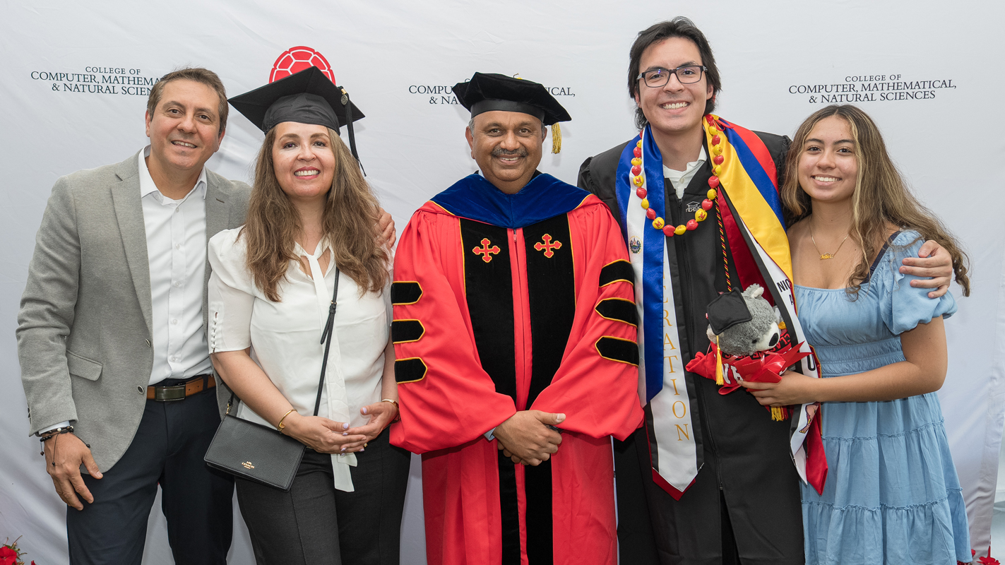 Dean Amitabh Varshney with a graduating student and his family.