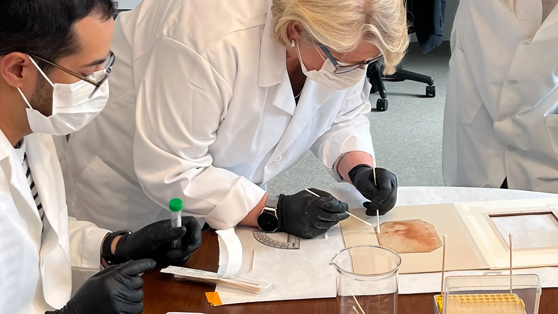 researcher in mask swabs back of "Holy Child"