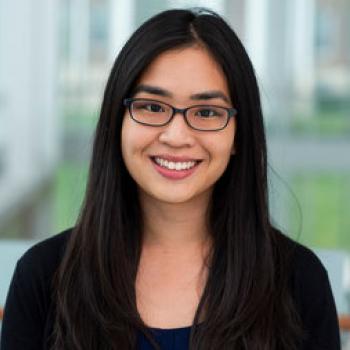 young asian woman wearing glasses and a black shirt smiling
