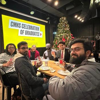 A group of 6 CMNS students at a party, lifting glasses with the SCIENCE TERP logo on them.