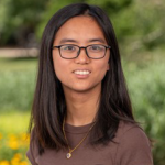 a young woman wearing glasses and a brown shirt