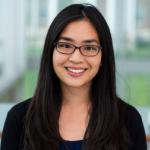 young asian woman wearing glasses and a black shirt smiling